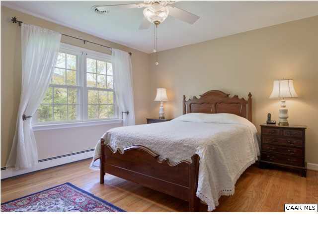 4284 Slam Gate Road Crozet, VA 22932 - Photo 8 of 30 a bedroom with a bed a chandelier and a window