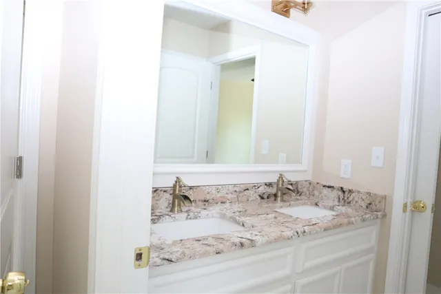 a bathroom with a granite countertop sink and a mirror