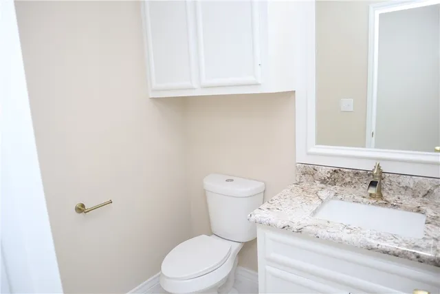 a white toilet sitting next to a bathroom sink