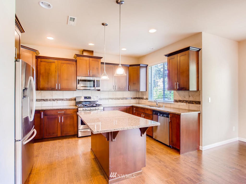 418 South 37th Street Renton, WA 98055 - Photo 8 of 24 a large kitchen with stainless steel appliances granite countertop a stove a sink dishwasher a microwave oven and a dining table with wooden cabinet