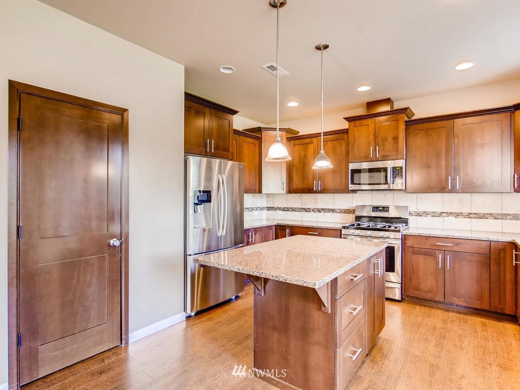 418 South 37th Street Renton, WA 98055 - Photo 9 of 24 a kitchen with stainless steel appliances granite countertop a refrigerator a sink a stove and a wooden floors