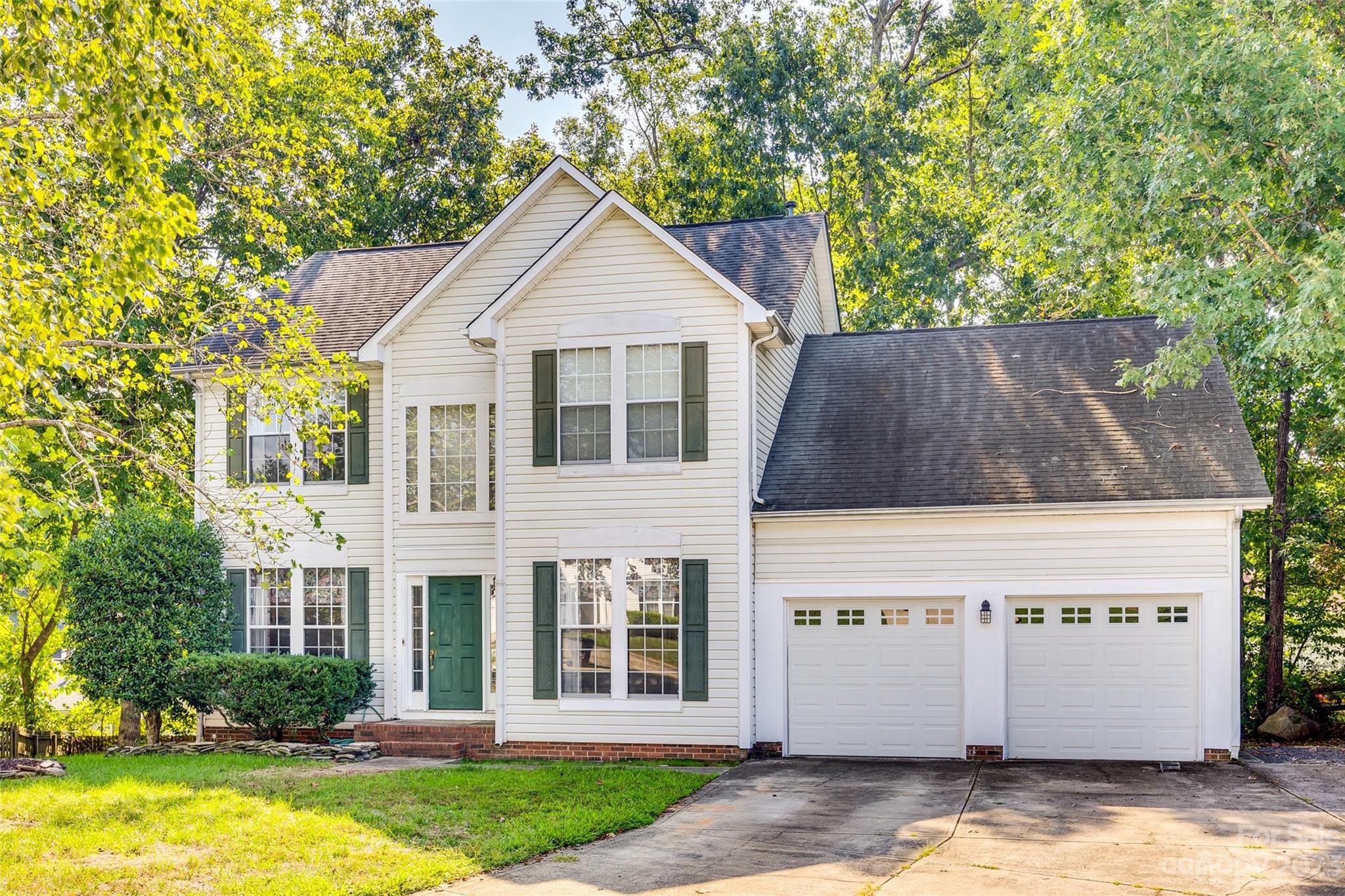 10305 Hatter Ridge Terrace Charlotte, NC 28214 - Photo 1 of 36 a view of a white house with a small yard plants and large tree