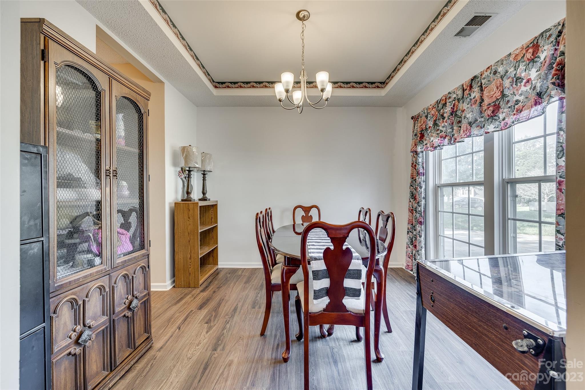10305 Hatter Ridge Terrace Charlotte, NC 28214 - Photo 6 of 36 a dining room with furniture a chandelier and wooden floor