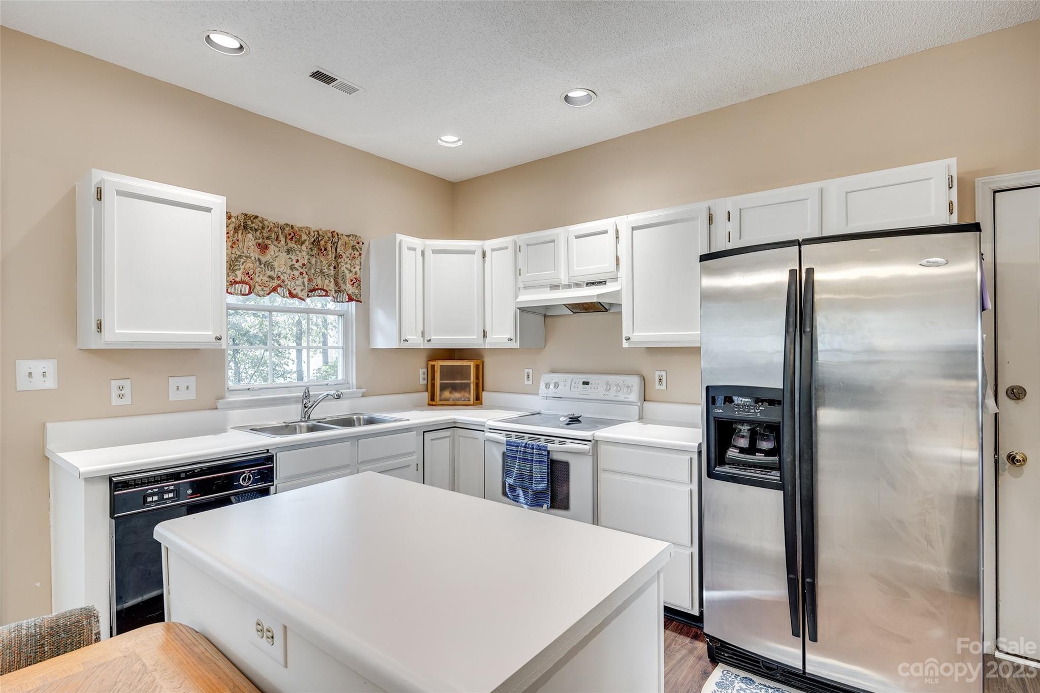 10305 Hatter Ridge Terrace Charlotte, NC 28214 - Photo 8 of 36 a kitchen with a refrigerator a sink a stove a refrigerator and cabinets