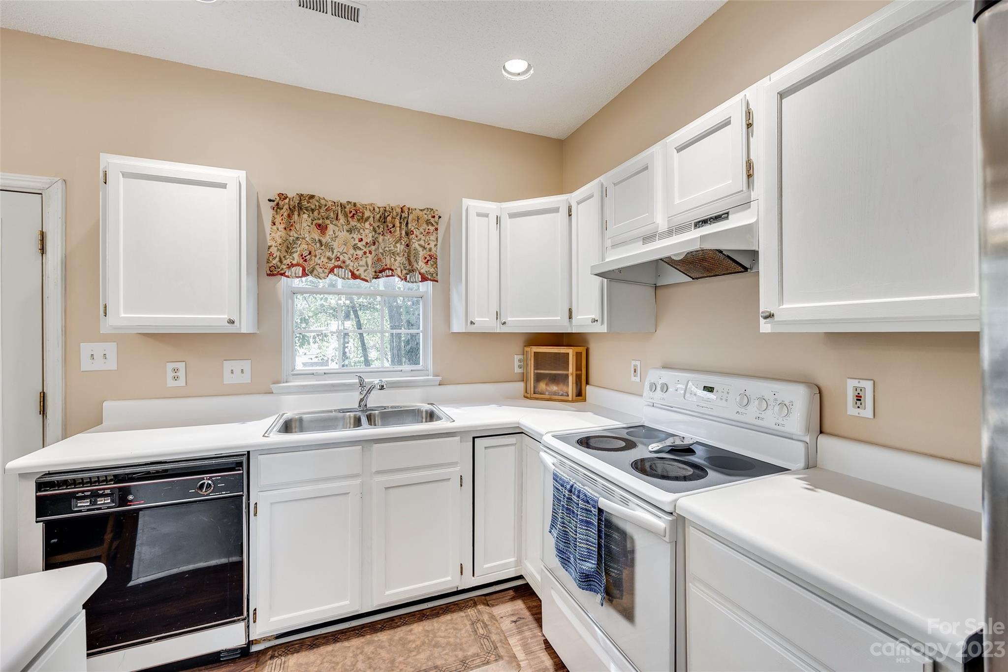10305 Hatter Ridge Terrace Charlotte, NC 28214 - Photo 10 of 36 a kitchen with stainless steel appliances a white stove top oven sink and cabinets