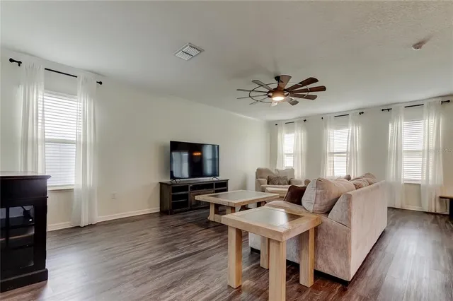 a living room with furniture and a wooden floor