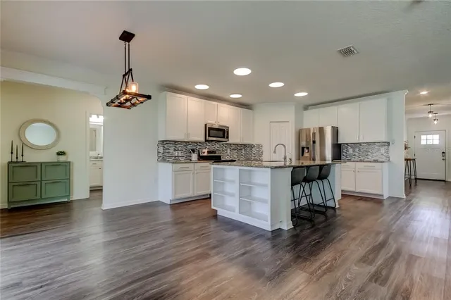 a kitchen with white cabinets and stainless steel appliances