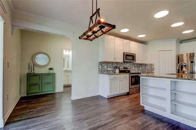 a view of a room with wooden floor staircase and a chandelier