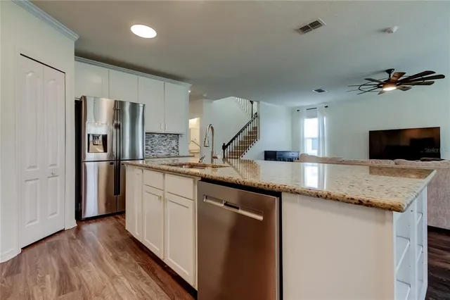 a kitchen with kitchen island granite countertop a sink cabinets and window