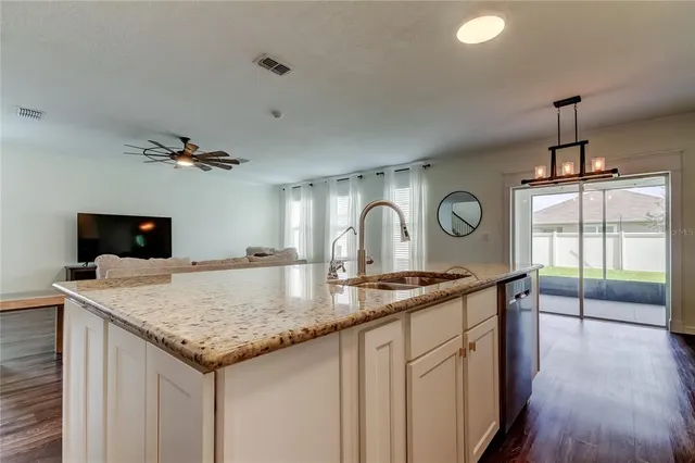 a kitchen with stainless steel appliances granite countertop a stove a sink and a refrigerator