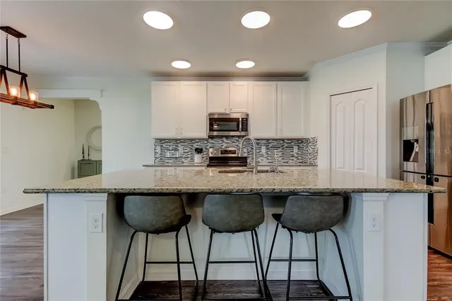 a bathroom with a granite countertop toilet a sink and a mirror