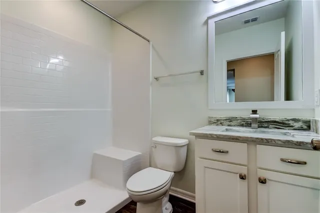 a bathroom with a granite countertop toilet a sink and a bathtub