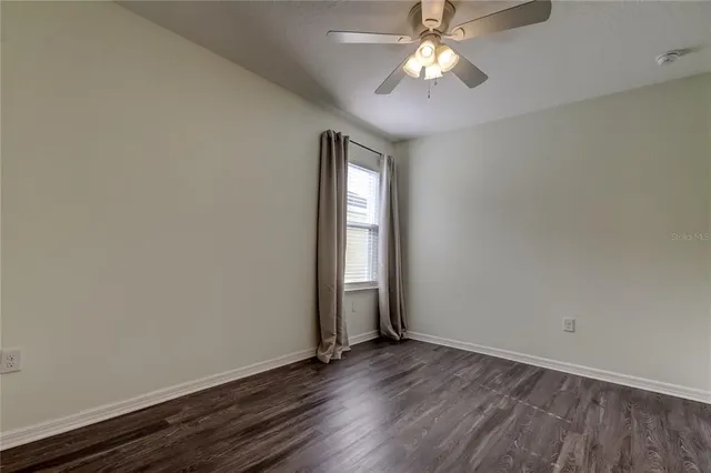 a view of a livingroom with a ceiling fan and window