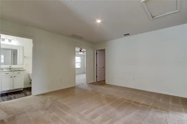 a view of an empty room with a chandelier fan