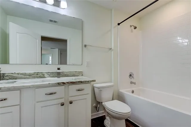 a bathroom with a granite countertop sink vanity and mirror