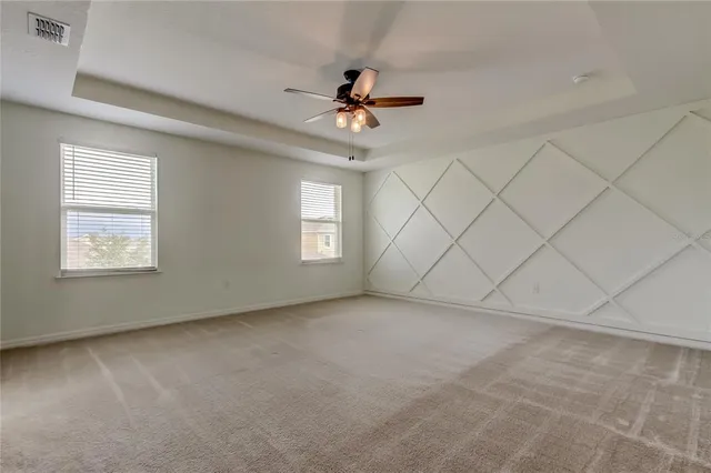 an empty room with a ceiling fan and window