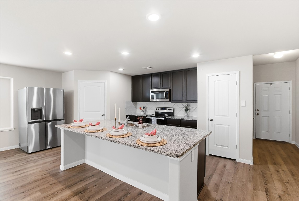 995 Rice Drive Bryan, TX 77803 - Photo 7 of 23 a kitchen with stainless steel appliances granite countertop a sink stove refrigerator and microwave