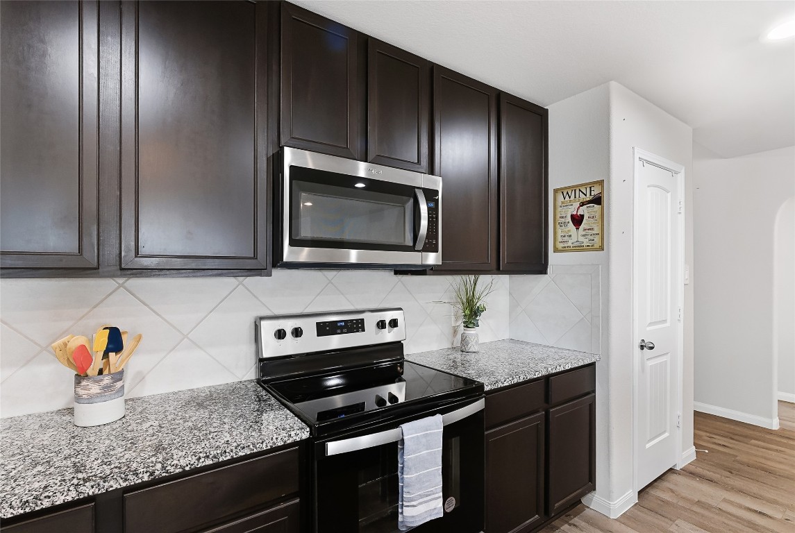 995 Rice Drive Bryan, TX 77803 - Photo 9 of 23 a kitchen with granite countertop stainless steel appliances a stove microwave and refrigerator