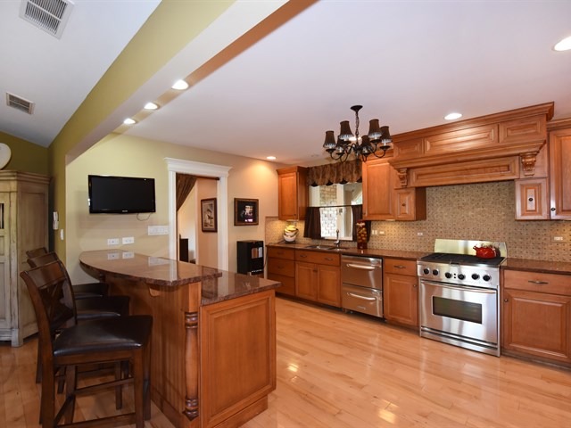 575 Aberdeen Road Frankfort, IL 60423 - Photo 13 of 25 a kitchen with stainless steel appliances kitchen island granite countertop a stove a sink and a microwave