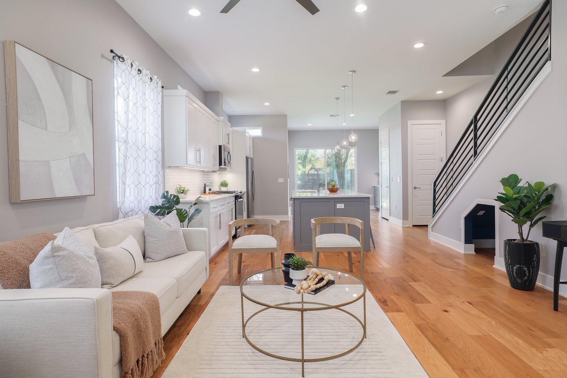 1103 Saucedo Street, Unit 2 Austin, TX 78721 - Photo 4 of 26 Oversized windows and high ceilings allow natural light to fill the main living space, highlighting the hardwood floors that run throughout the entire home