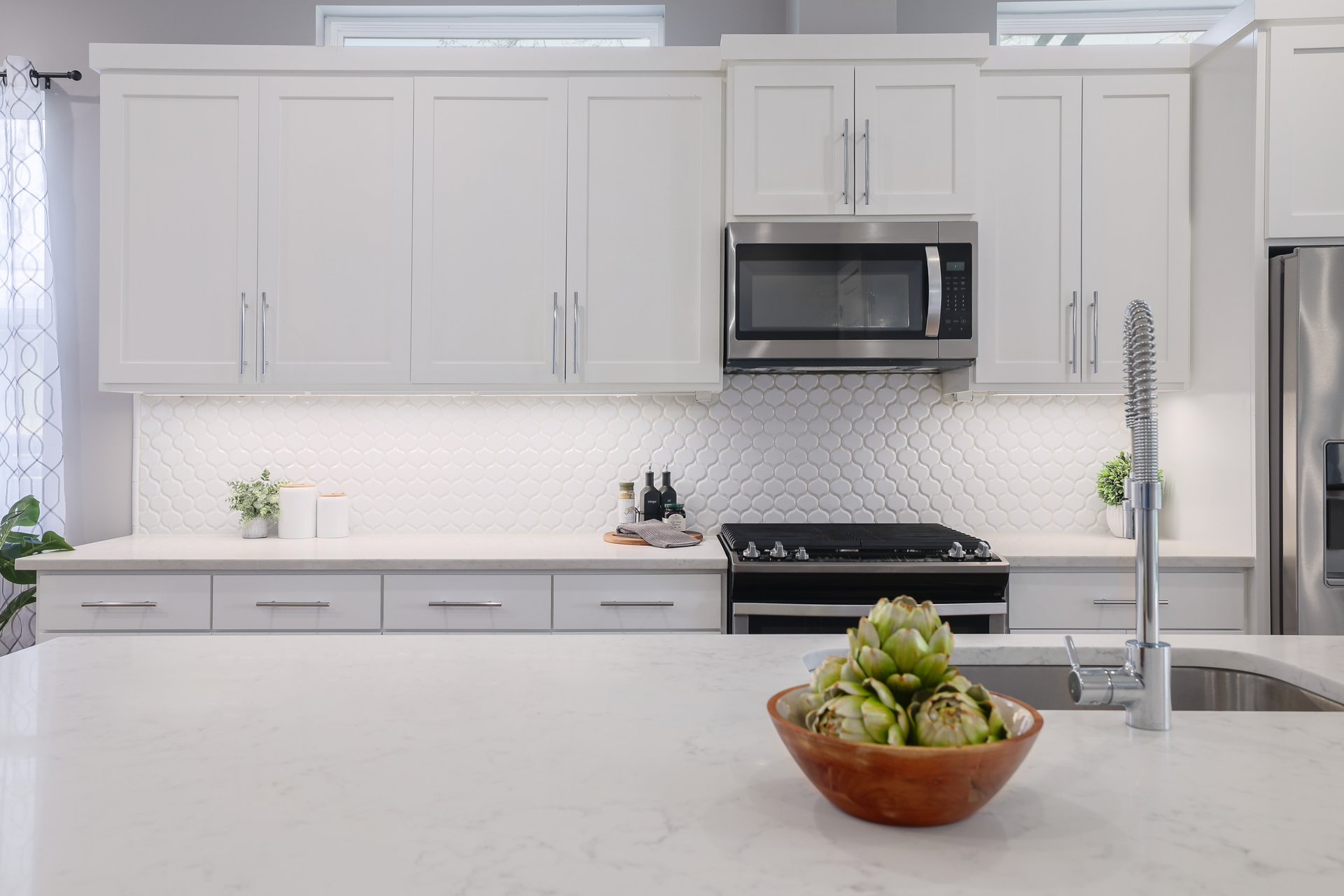 1103 Saucedo Street, Unit 2 Austin, TX 78721 - Photo 9 of 26 Undercabinet lighting provides a warm glow over the prep areas, complementing the suite of stainless steel appliances and custom cabinetry