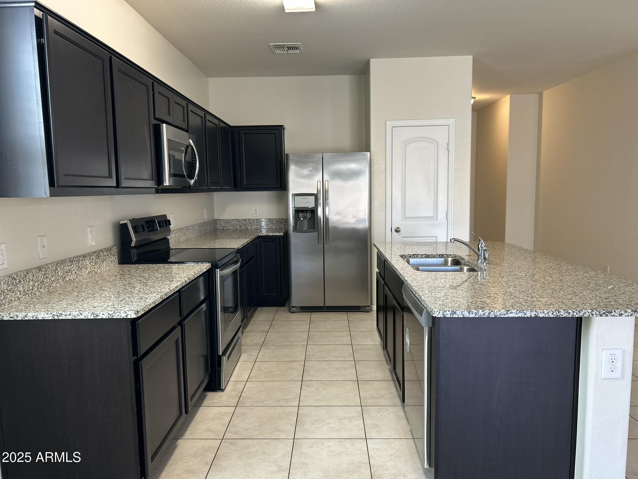4734 East Pearl Road San Tan Valley, AZ 85143 - Photo 12 of 27 a kitchen with stainless steel appliances granite countertop a sink stove and refrigerator