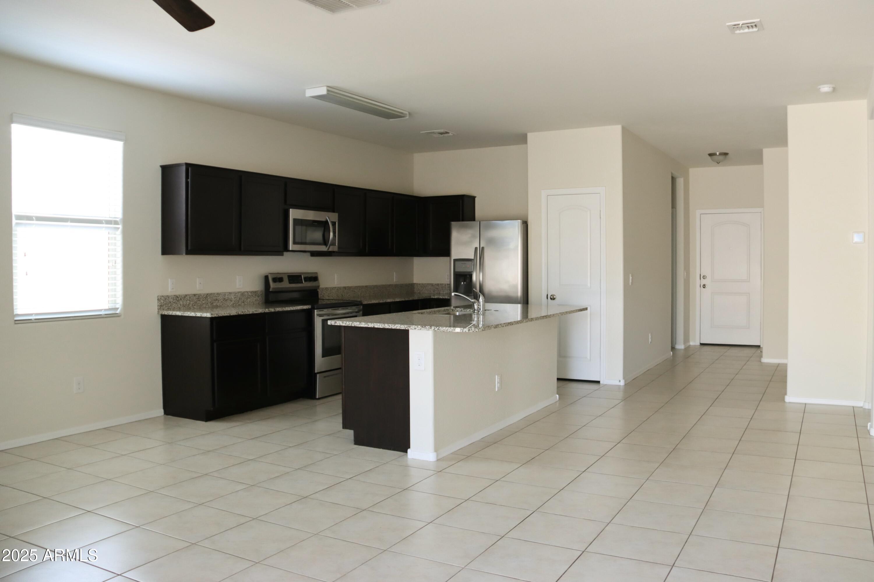 4734 East Pearl Road San Tan Valley, AZ 85143 - Photo 9 of 27 a kitchen with stainless steel appliances granite countertop a refrigerator and a stove top oven