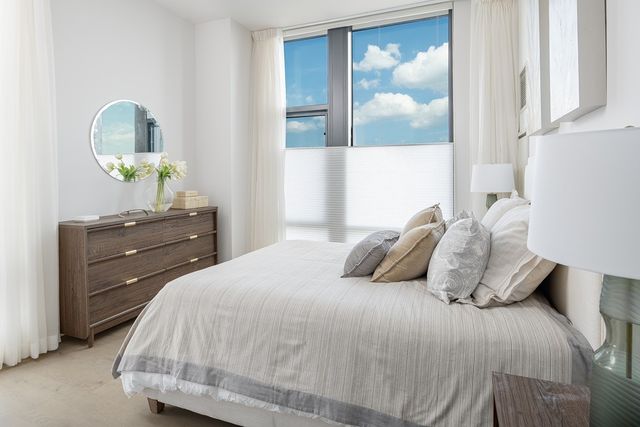 a bedroom with a bed and painting on the wall