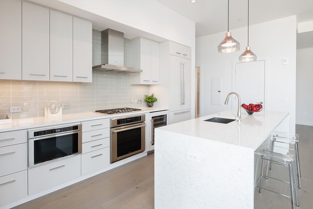 a kitchen with a sink stove and white cabinets