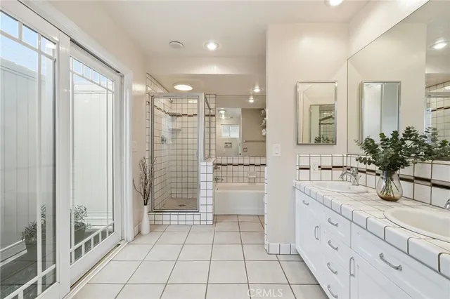 a bathroom with a double vanity sink a mirror and a shower