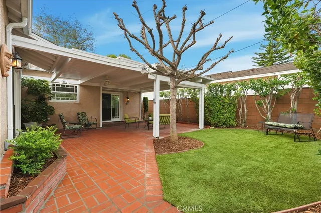 a view of a house with backyard and sitting area