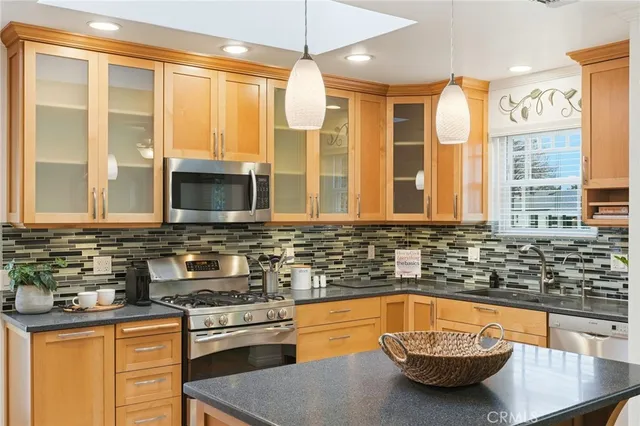 a kitchen with stainless steel appliances granite countertop a sink and a stove