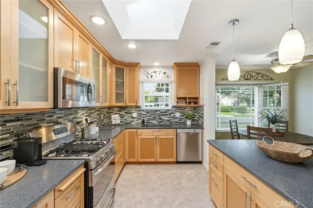 a kitchen with stainless steel appliances granite countertop a sink stove and cabinets