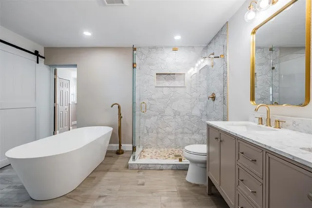 a bathroom with a white tub toilet and shower