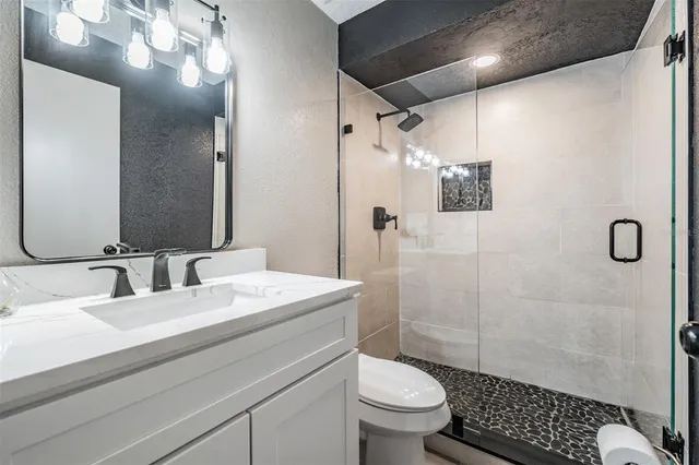 a bathroom with a sink a toilet and shower