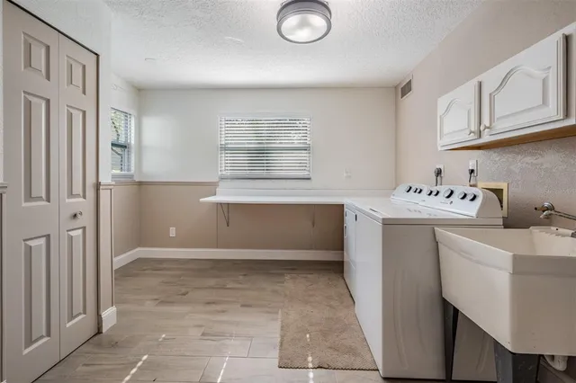 a utility room with cabinets dryer and washer