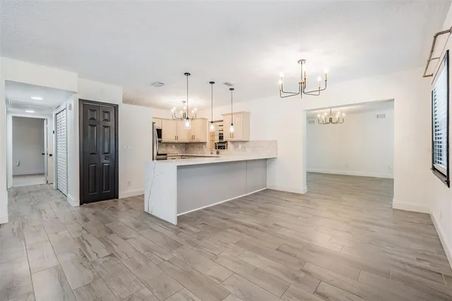 a view of a kitchen with kitchen island wooden floors appliances and cabinets