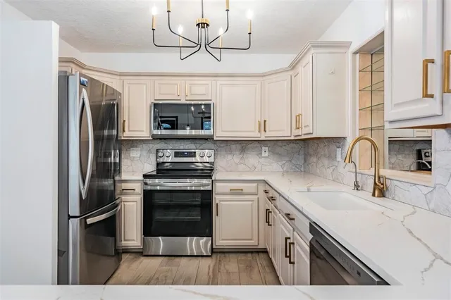 a kitchen with stainless steel appliances a stove microwave and a refrigerator