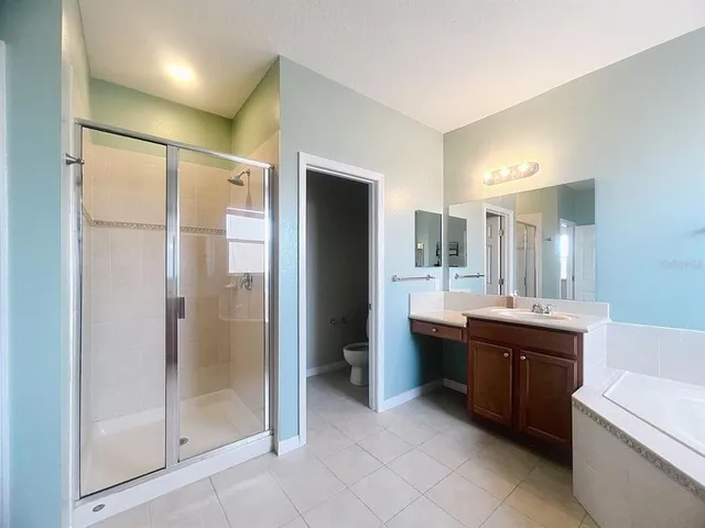 a bathroom with a tub sink and mirror