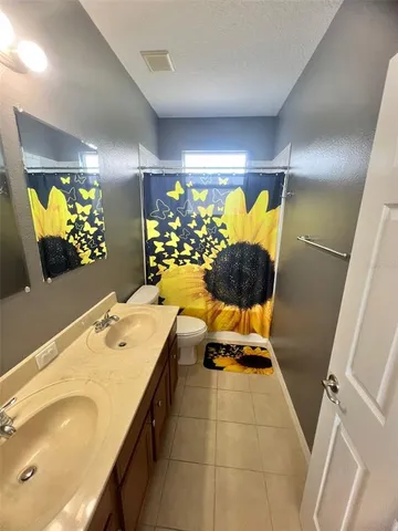 an empty room with wooden floor and a ceiling fan