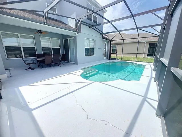 a backyard with table and chairs and potted plants