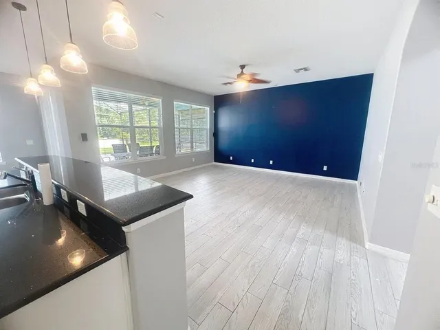 a kitchen with a sink and wooden floor