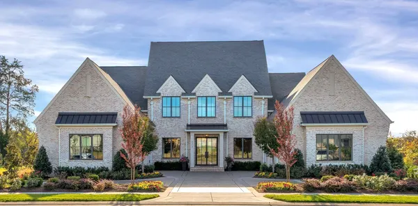 a front view of a house with yard garage and windows