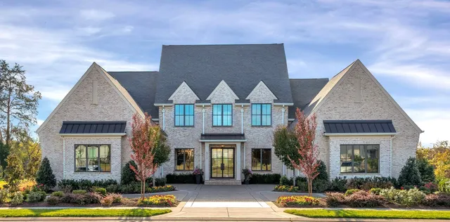 a front view of a house with yard garage and windows