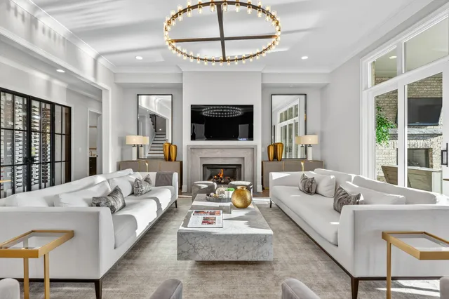 a living room with stainless steel appliances furniture a chandelier a kitchen view and a chandelier