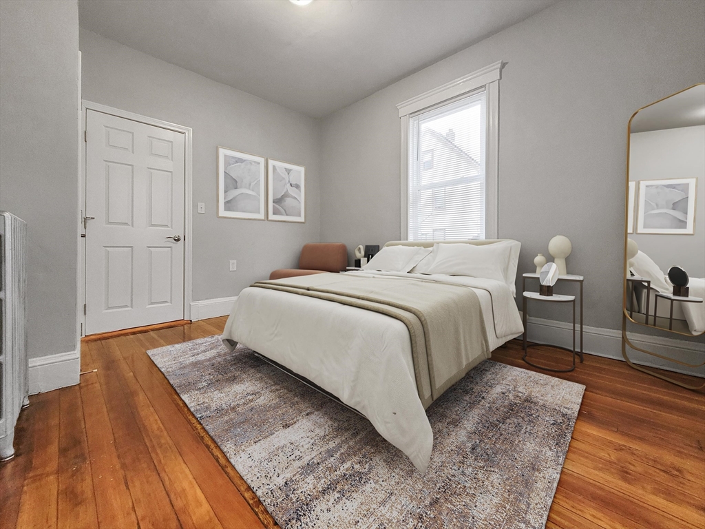 108 Callender Street, Unit 1 Boston, MA 02124 - Photo 4 of 9 a bedroom with a bed and wooden floor