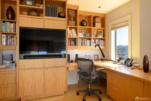 a view of a workspace with furniture and a window