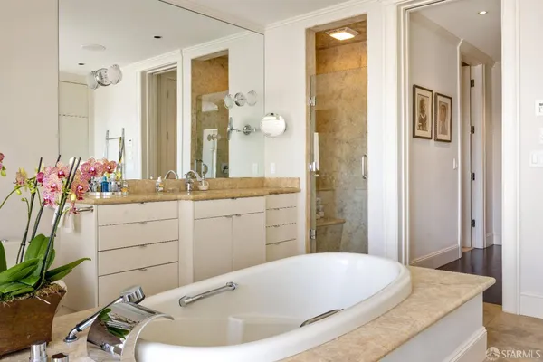 a bathroom with a tub sink and mirror