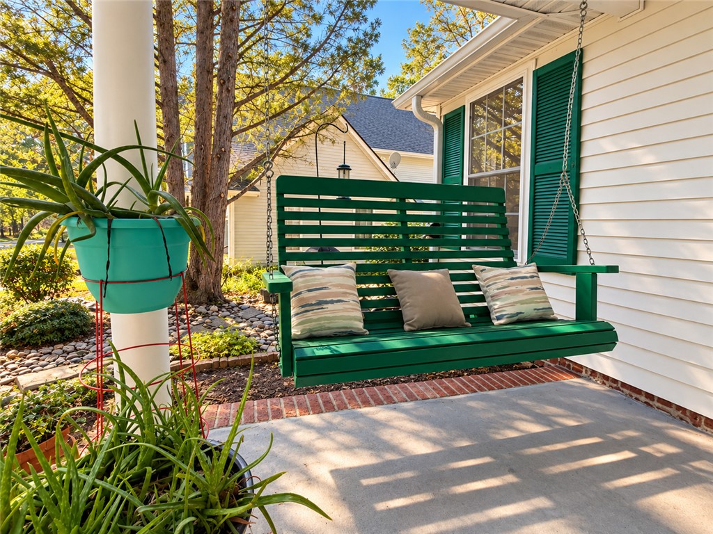 A welcoming front porch features classic siding and coordinates with nearby shade trees.