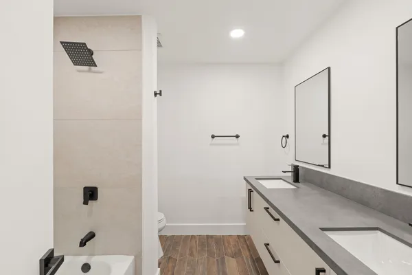 a bathroom with a granite countertop sink a mirror and shower